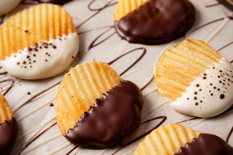 RUFFLES potato chips half-dipped in dark and white chocolate on parchment paper