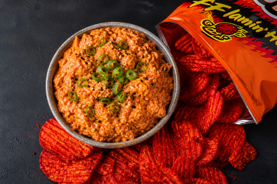 A bowl of gochujang tuna salad dip served beside RUFFLES FLAMIN' HOT potato chips